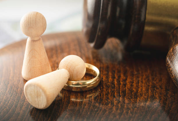 Divorce - Fallen human figure on a wedding ring and mallet